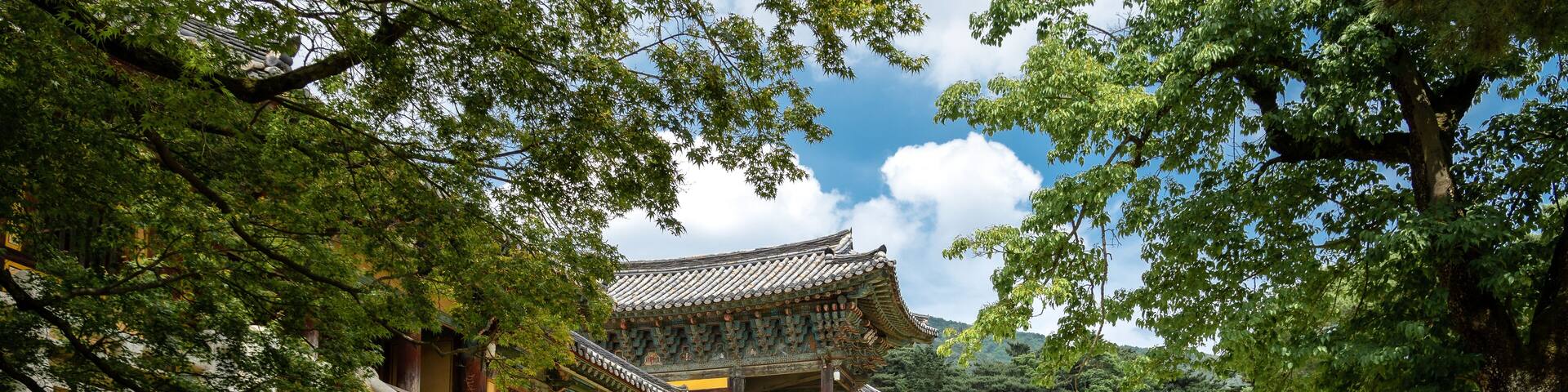 A traditional Korean building with a stone staircase leading to a wooden gate.