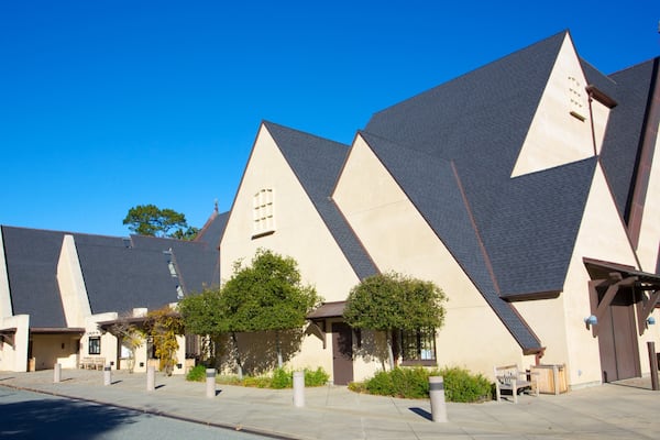 A modern building with a unique geometric design, featuring triangular roofs and beige walls.