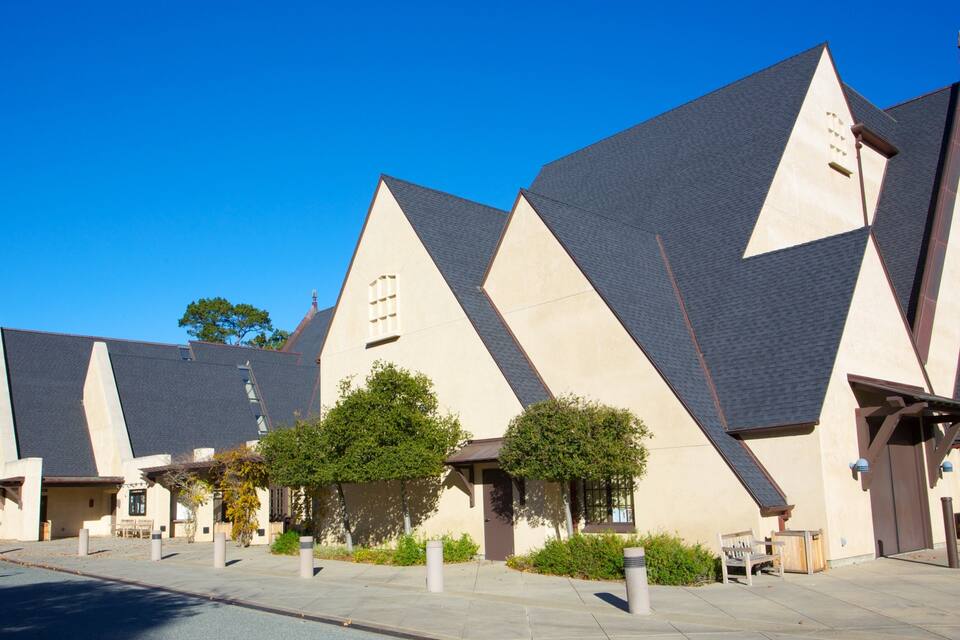 A modern building with a unique geometric design, featuring triangular roofs and beige walls.