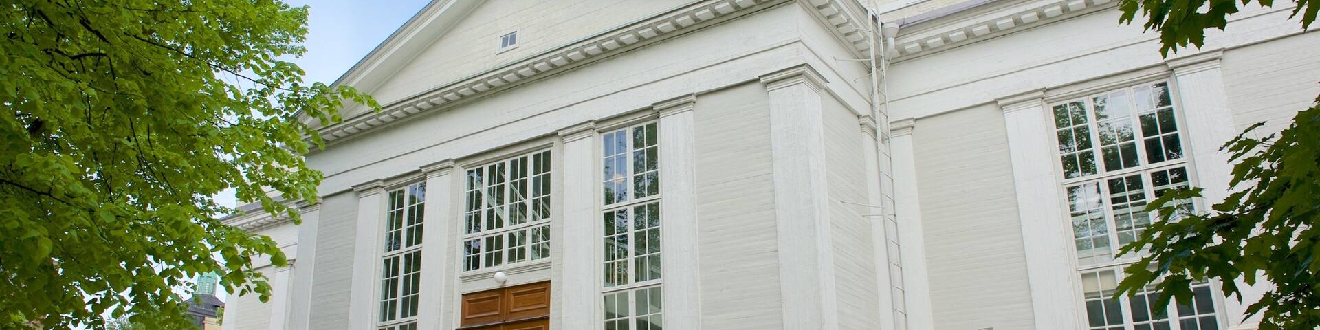A white building with large windows and a wooden door.