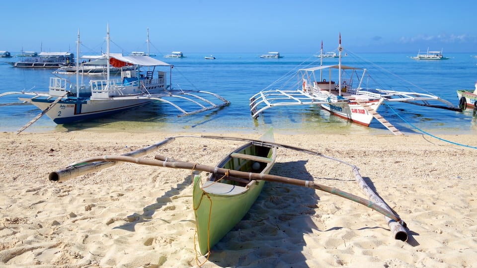 A beach with traditional boats and a clear blue sea.