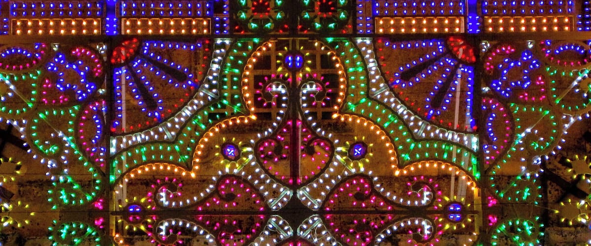 The "luminarie" (luminary) in Ortelle. Saint George and Saint Fortunato festival.
Everyone knows the Salento for its beautiful beaches and its views, for the goodness of local cuisine and the charm of its many traditions. But few may know that the Salento is also famous for many other aspects, which are revealed to visitors especially during the numerous festivities spread inland. We are talking about the incredible interplay of light of the illuminations, also called villas: these little colored lights which cover entire buildings as waterfalls, churches, streets and squares, forming unique settings can keep their eyes upward everyone from the largest to the smallest.