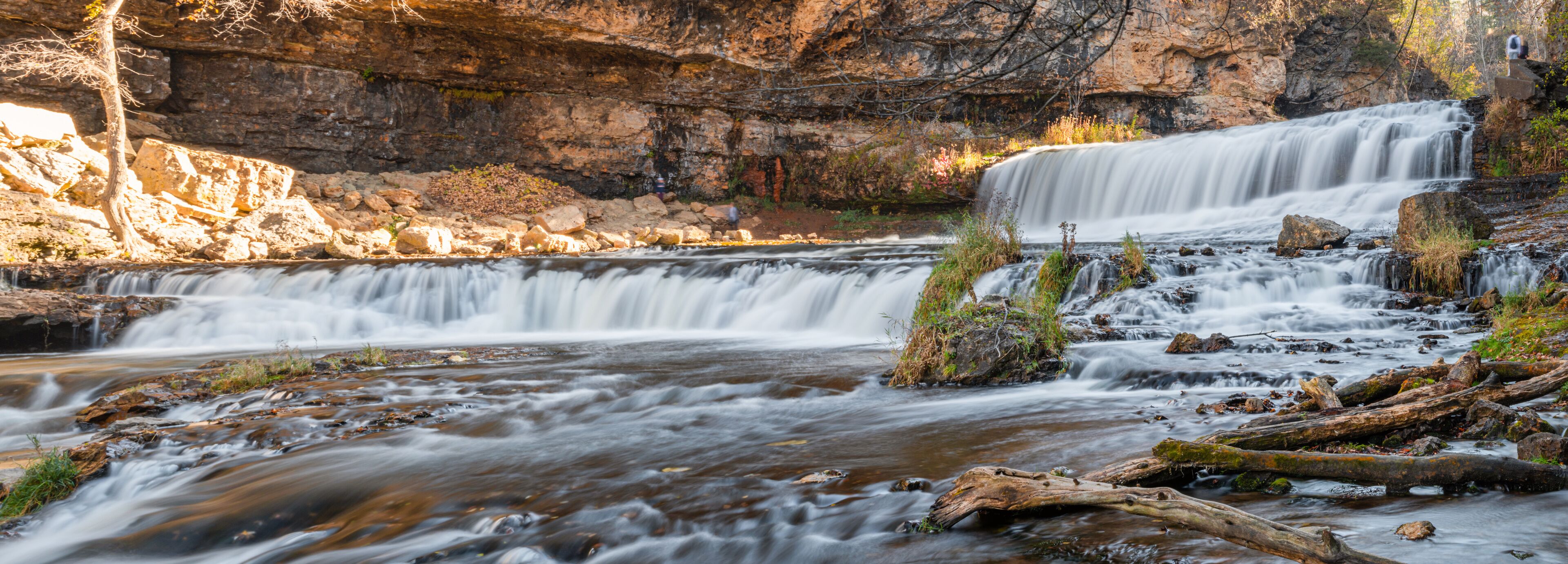 A waterfall cascading over rocks in a forested area.