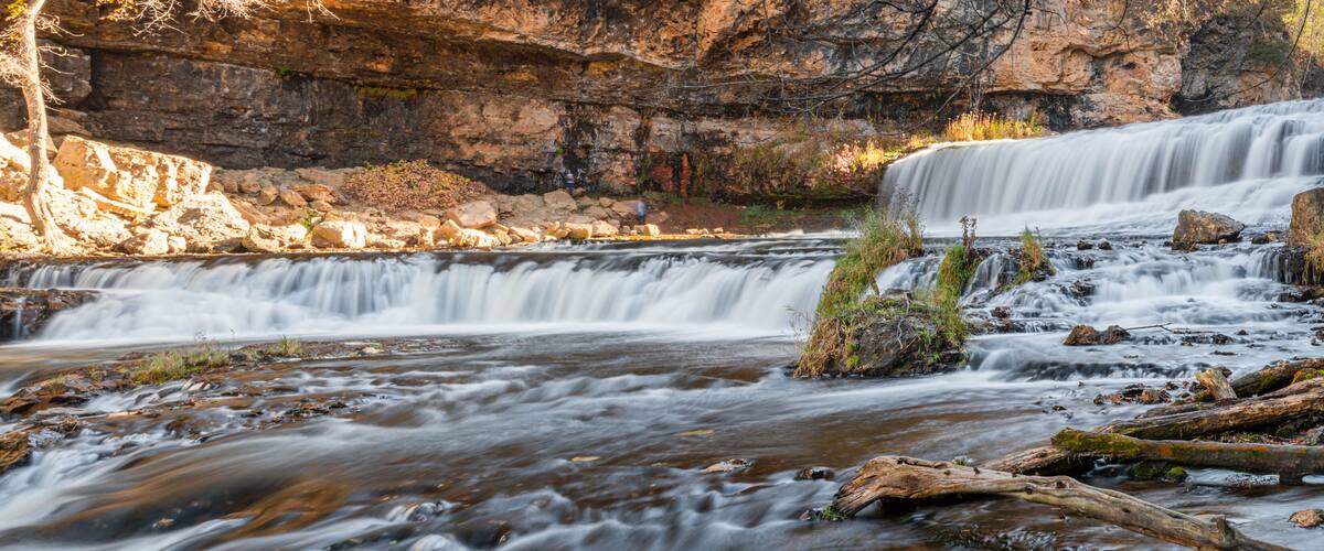 A waterfall cascading over rocks in a forested area.