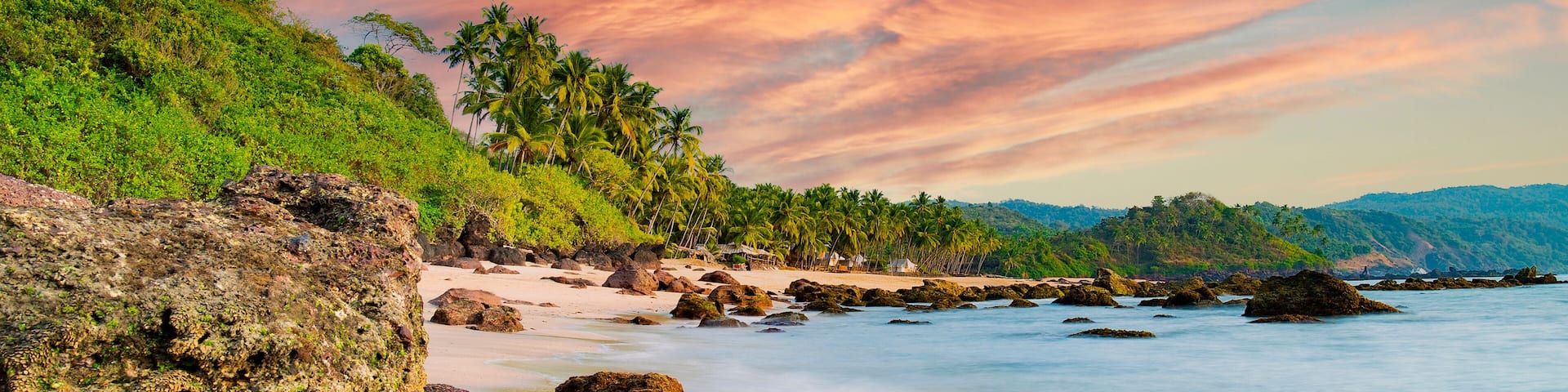 Long exposure. Beautiful and relaxing beach flanked by green palm trees at sunset. Varkala, Kerala, India.