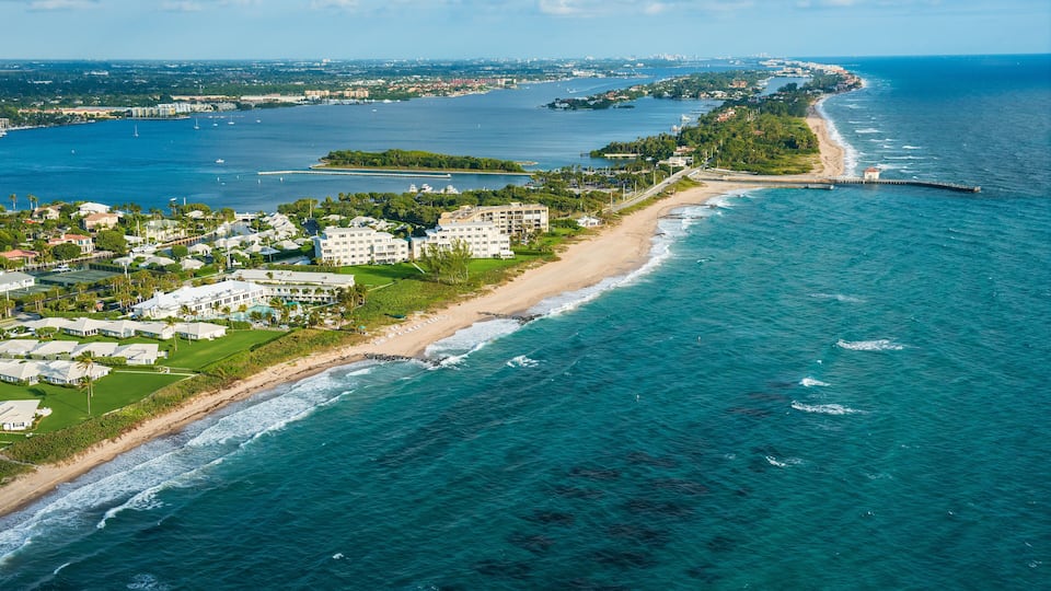 A coastal town with a beach, ocean, and residential buildings.