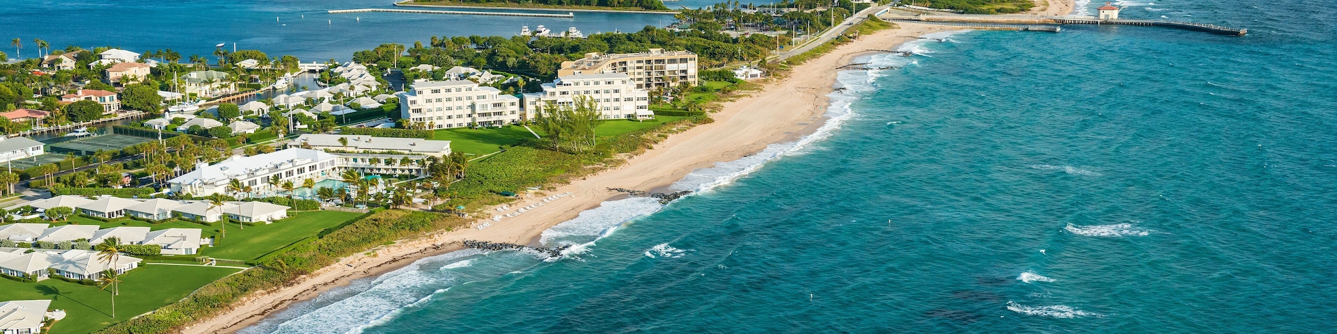 aerial view of atlantic ocean shoreline, intracoastal inlet and pier at boynton beach florida, with palm beach in the distance