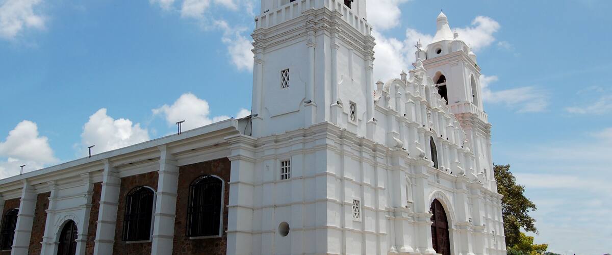 A white church with two towers and a clock.