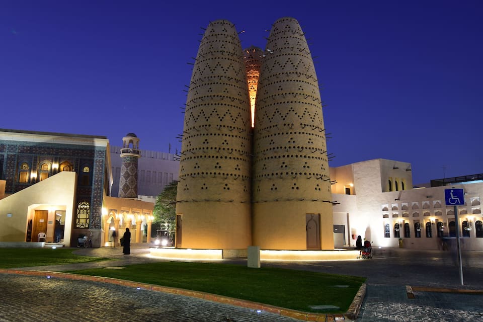 Un bâtiment moderne doté de deux hautes tours cylindriques, dont la façade est ornée d’un motif de trous.
