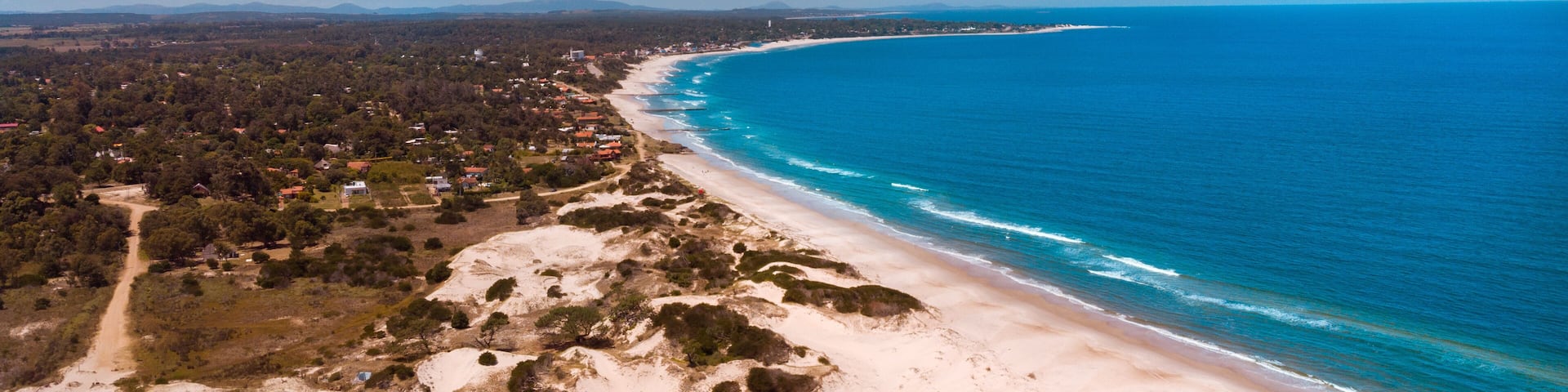 Beautiful view of the clear blue skies over the ocean and the sand in Canelones, Uruguay