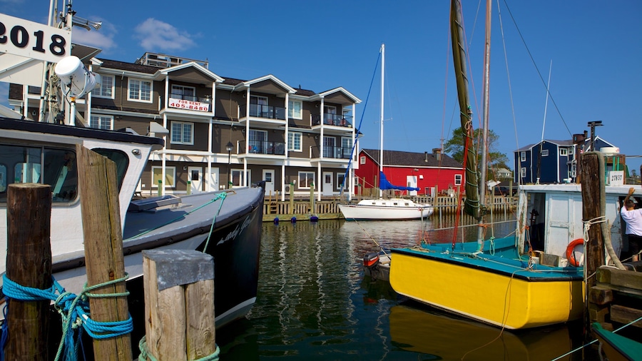 A marina with boats docked, a red building, and a multi-story residential building in the background.