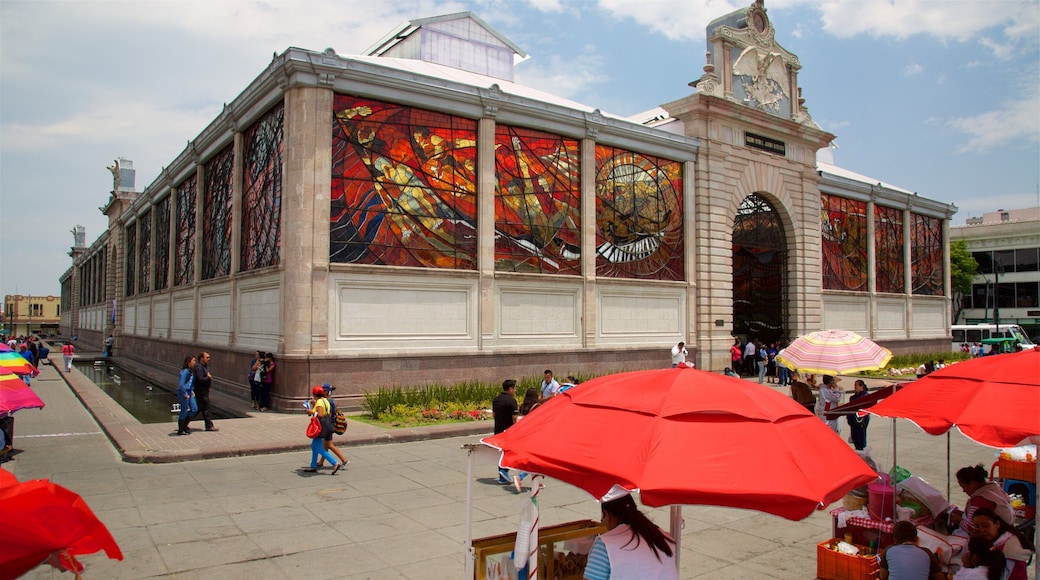 The Cosmovitral featuring a square or plaza and heritage architecture as well as a small group of people