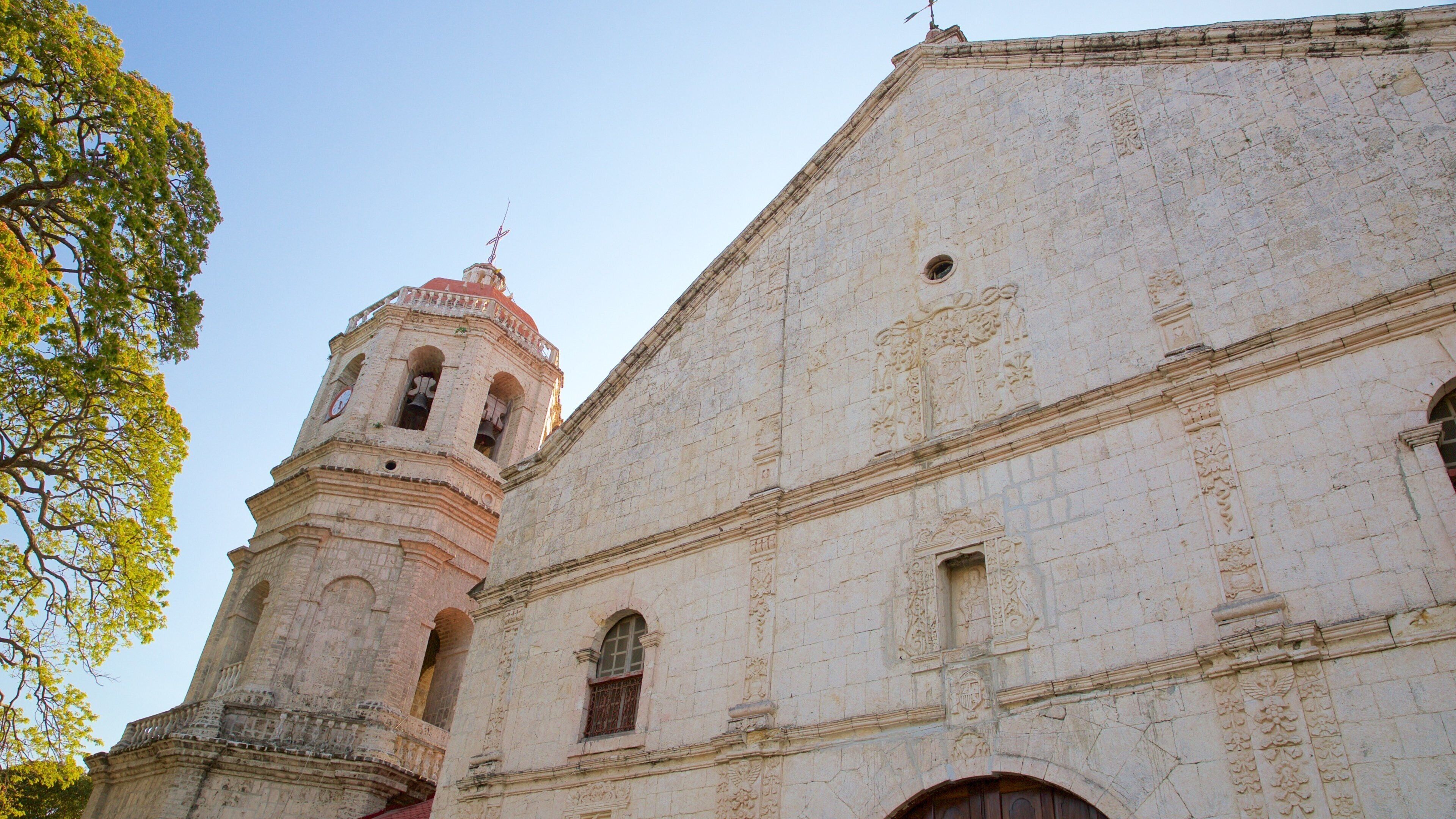 Iglesia de Dalaguete que incluye aspectos religiosos, arquitectura patrimonial y un atardecer