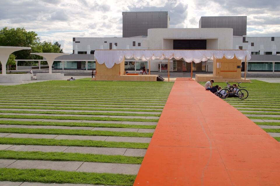 A modern building with a red pathway leading to it.