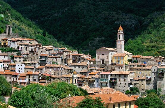 A hillside village with terracotta-roofed buildings and a prominent tower.