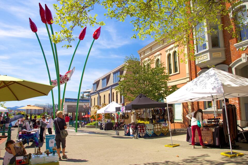 Un marché animé en plein air, avec des étals, des tentes et un bâtiment historique en arrière-plan.