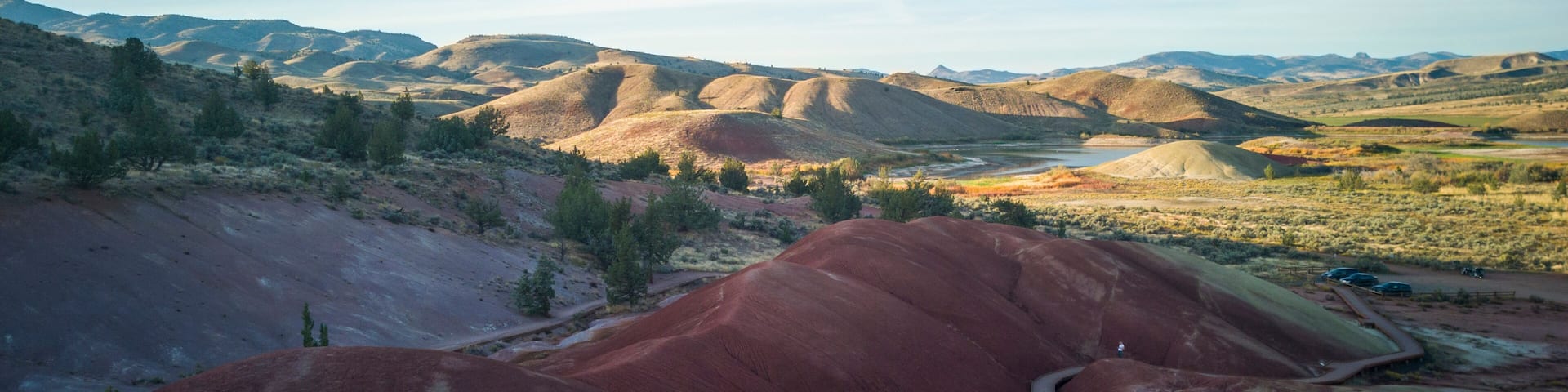 Breathtaking colorful red and white clay fossil beds with a beautiful semi desert background with big white clouds and a blue sky at the John Day Fossil Beds Painted Cove Trail in Oregon