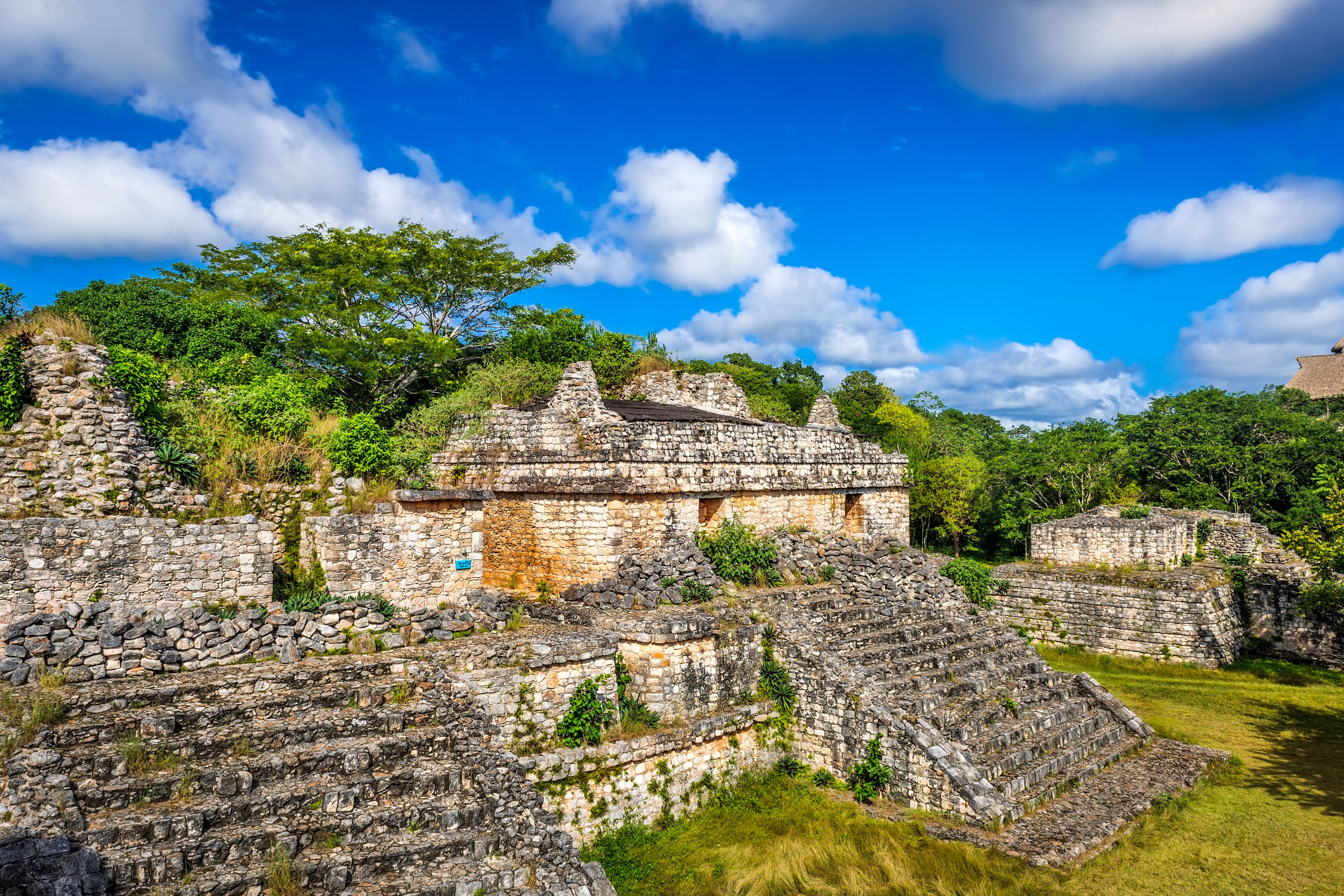 Ancient stone ruins with stepped structures and a clear blue sky.