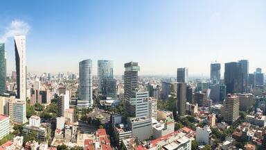 Paisagem urbana com vários arranha-céus, céu azul límpido e uma mistura de arquitetura moderna e mais antiga.