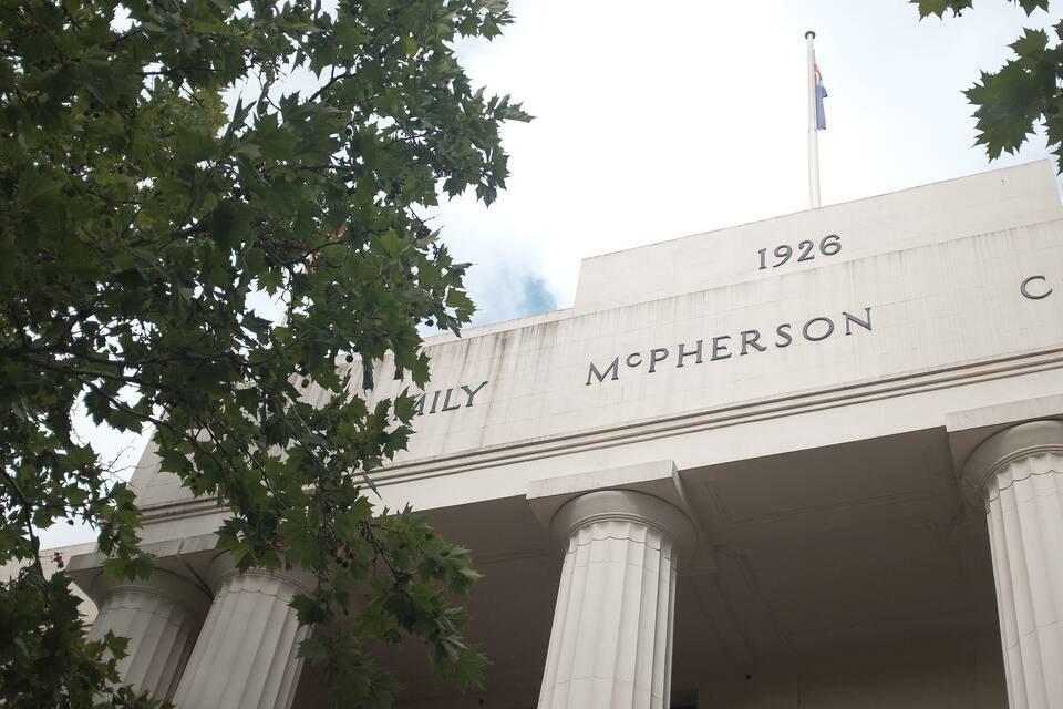 The McPherson College building with columns and a flag.