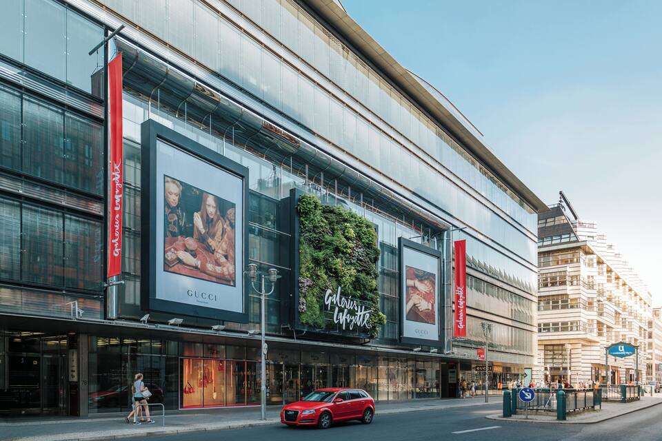 A modern building with large glass windows and red banners.