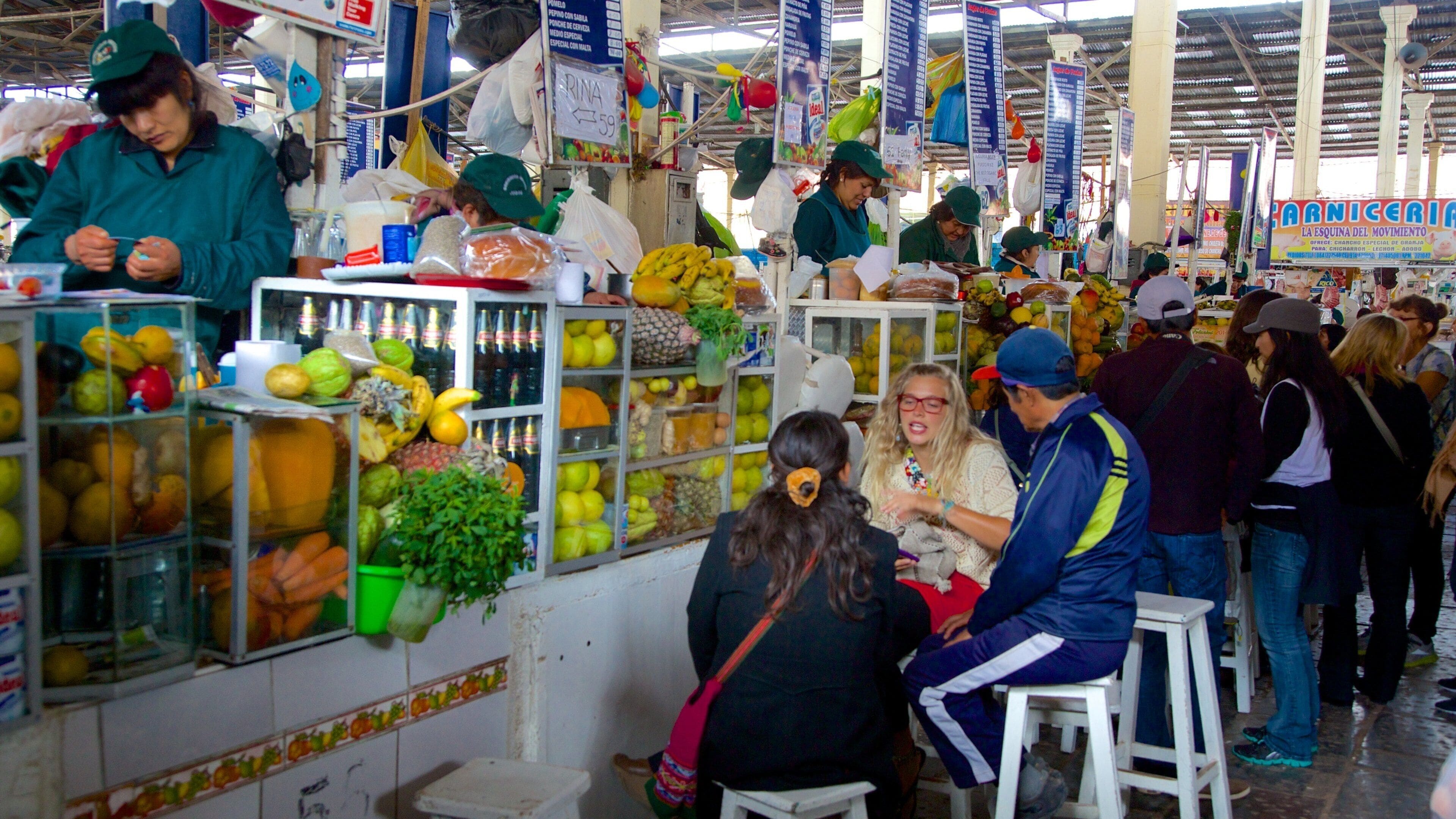 Cusco San Pedro Market featuring shopping and markets as well as a small group of people