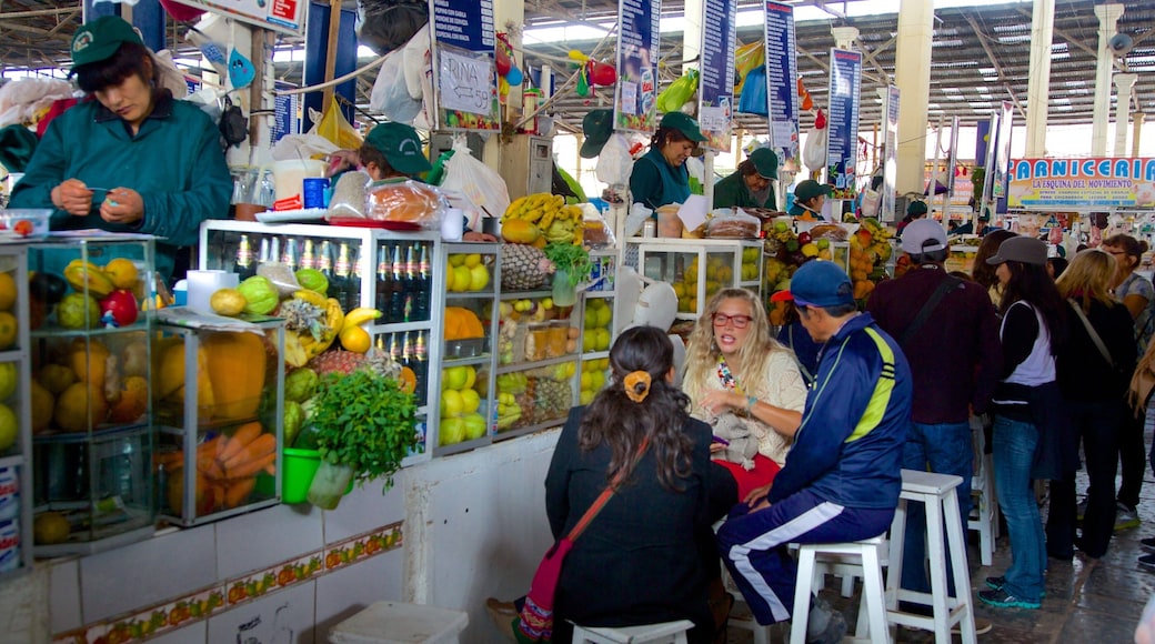 Cusco San Pedro Market featuring shopping and markets as well as a small group of people