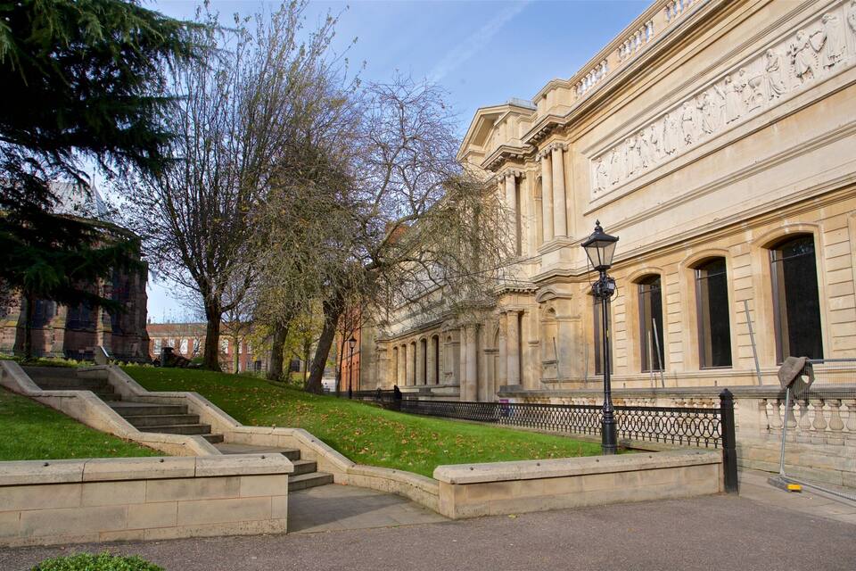 A historic building with classical architecture, a set of stone steps, and a lamppost.