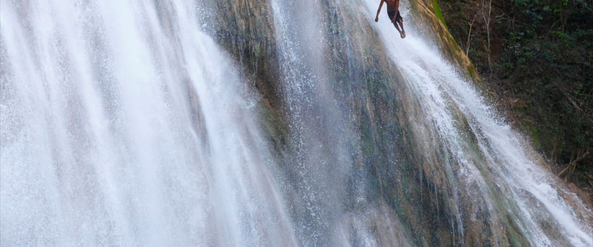 El Limon Falls featuring a waterfall as well as an individual male