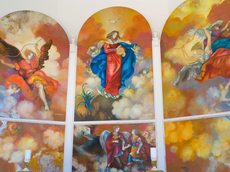 A triptych mural with religious figures and angels.