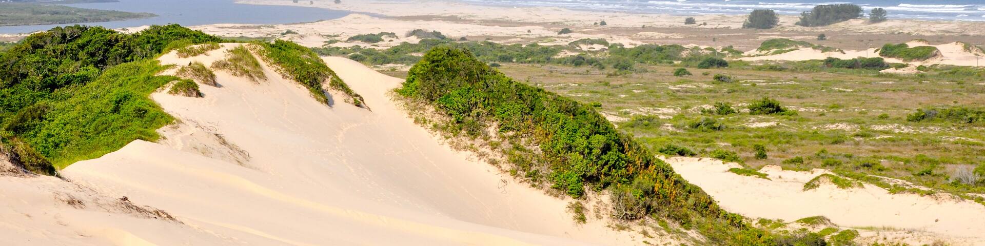 Sand dunes in with a ocean in Araranguá, Brazil