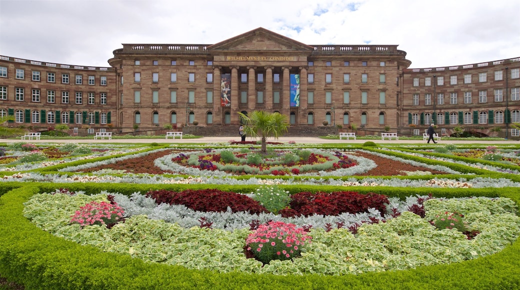 Schloss Wilhelmshoehe que incluye un parque, flores y arquitectura patrimonial