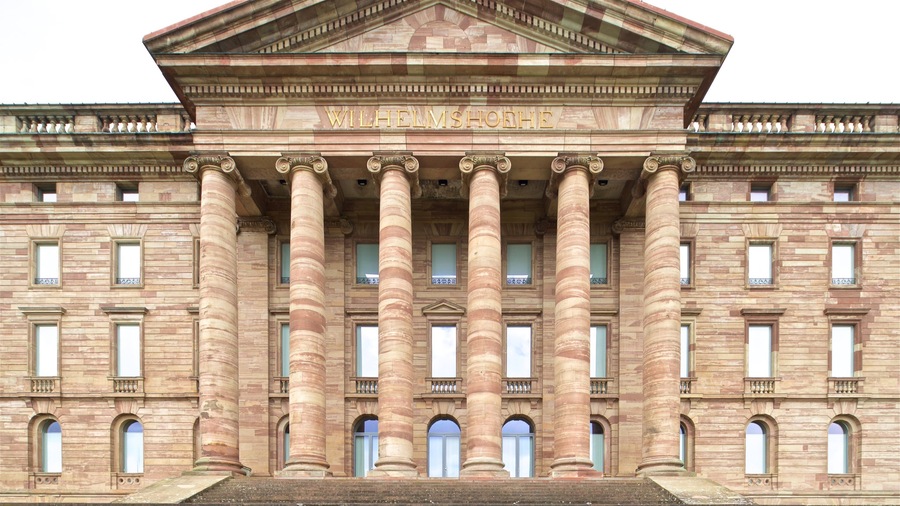 Ein großes, neoklassizistisches Gebäude mit sechs Säulen und einem Dreiecksgiebel.