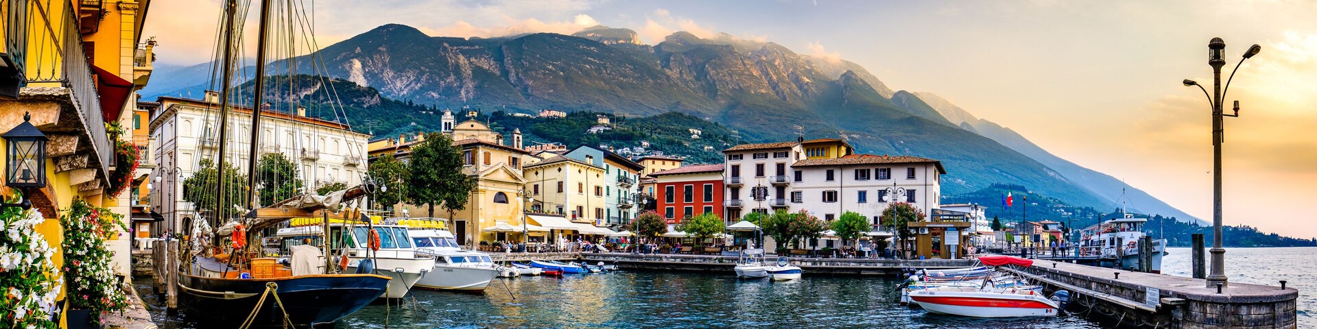 A harbor with boats, colorful buildings, and a mountain in the background.