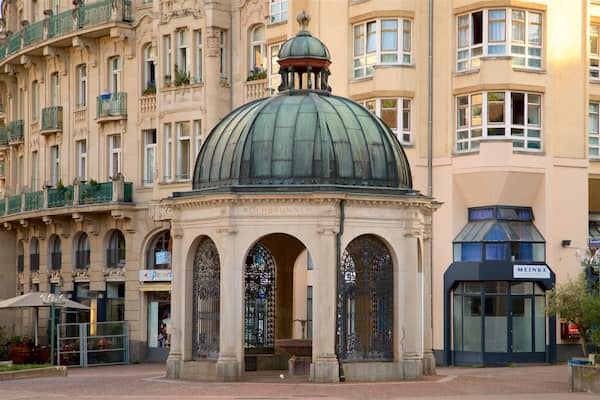 A historic building with a prominent dome and ornate iron gates.