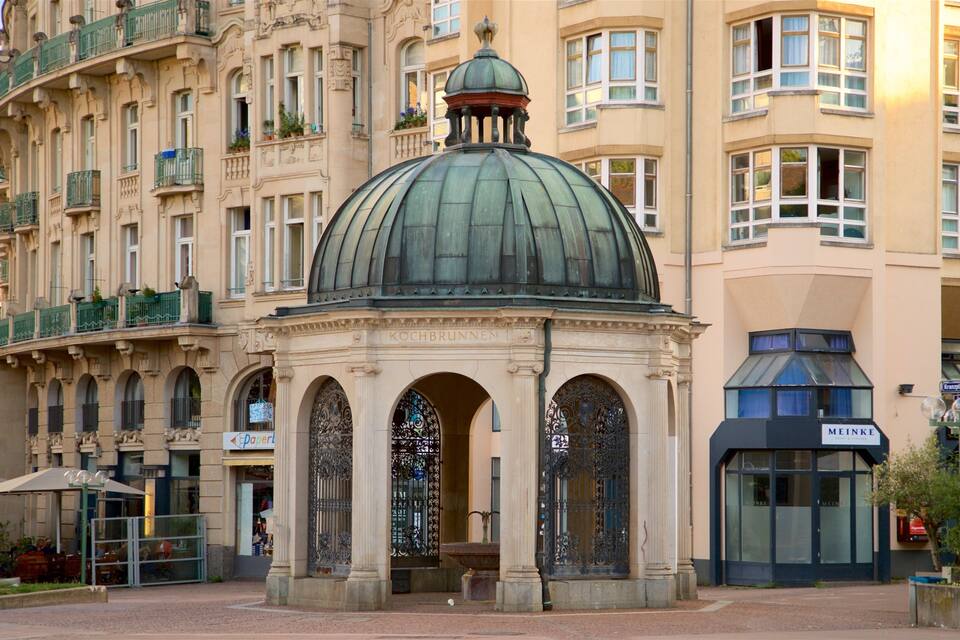 Um edifício histórico com uma cúpula imponente e portões de ferro elaborados.