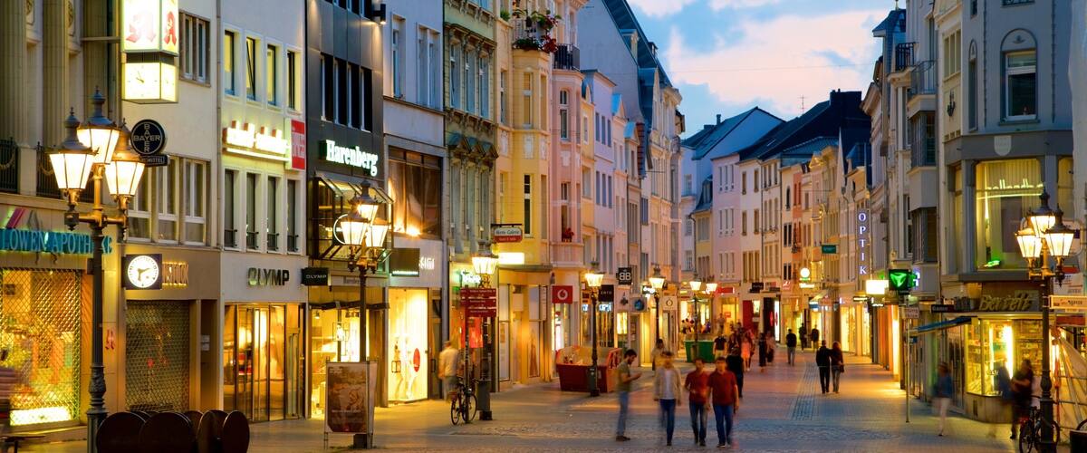 A cobblestone street lined with historic buildings, shops, and cafes.