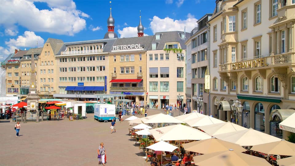 A bustling square with cafes, a market, and a prominent Metropol building.