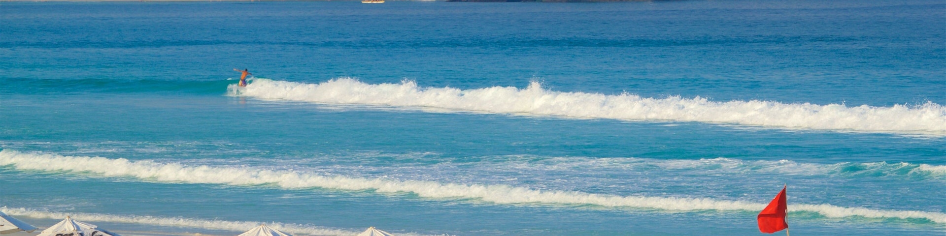 Playa de las Dunas que incluye vistas de una costa y una playa de arena y también un grupo pequeño de personas