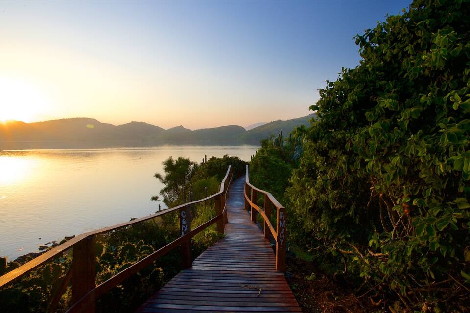 Une promenade en bois qui mène à un plan d’eau, avec des montagnes en arrière-plan.