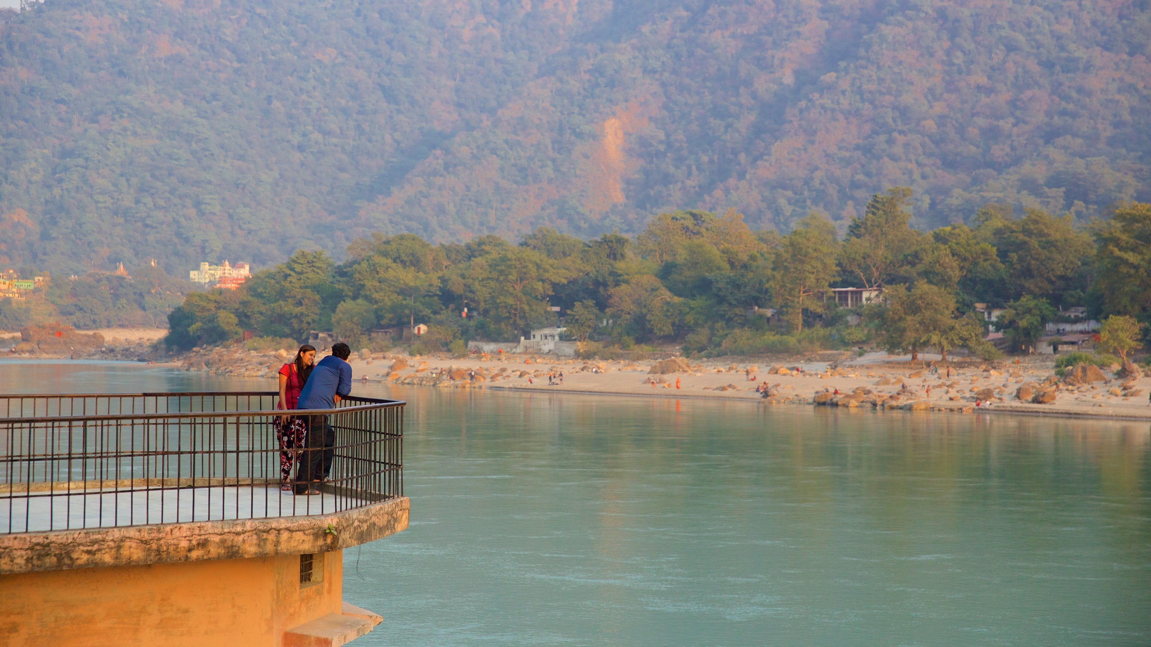 Ram Jhula que incluye escenas tranquilas y un río o arroyo y también un pequeño grupo de personas