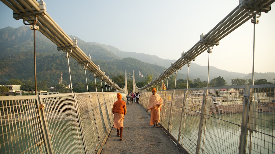 Ram Jhula which includes a suspension bridge or treetop walkway and a small town or village as well as a small group of people