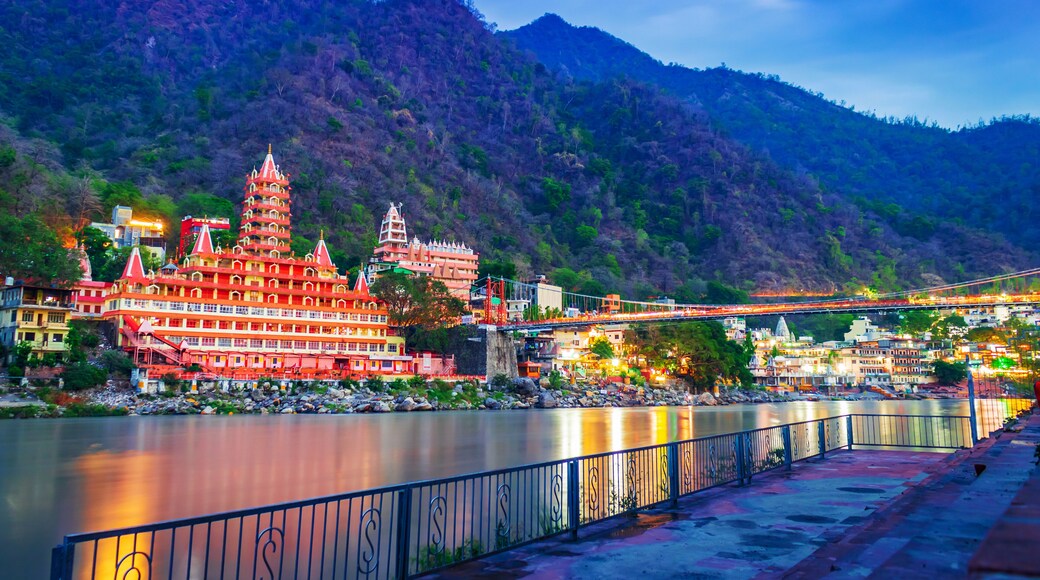 River Ganges, the famous bridge Laxman Jhula surrounded by temples and mountains around in rishikesh, India