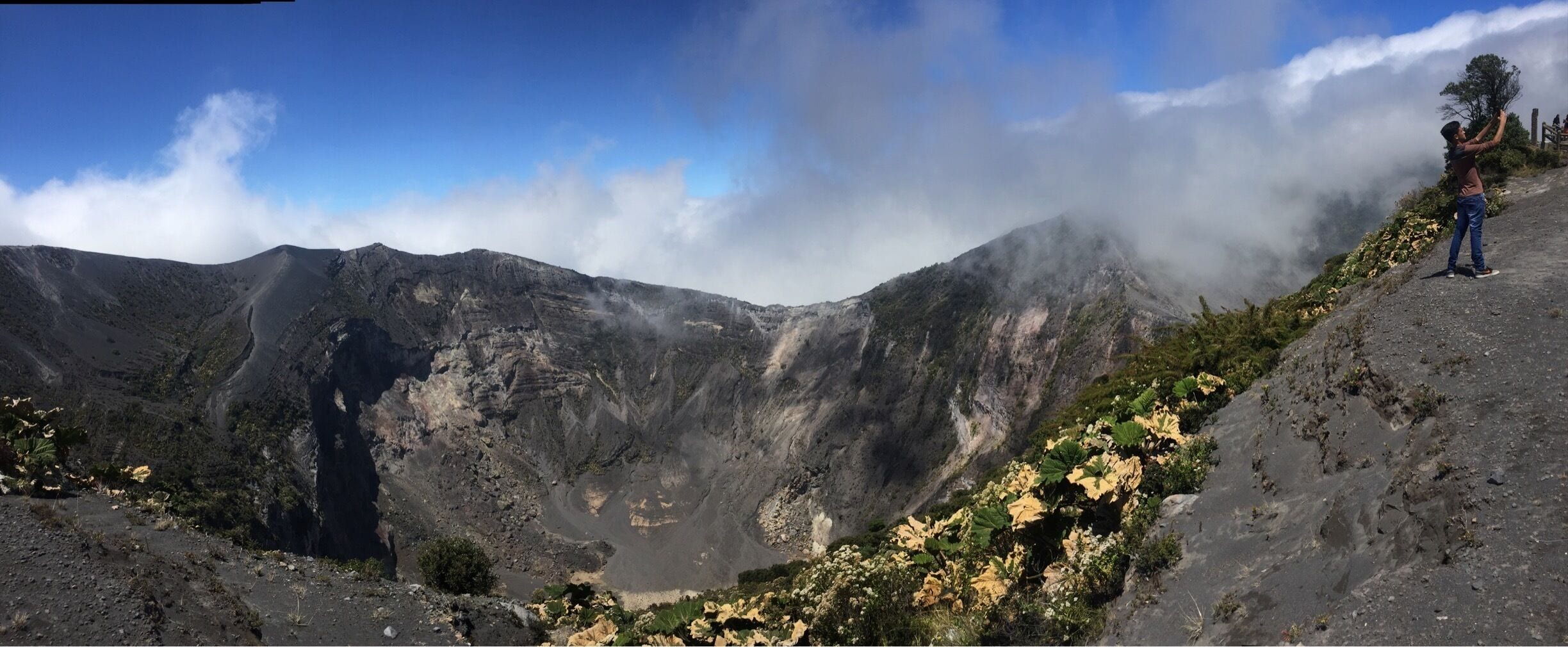 A mountainous landscape with a person standing on a ridge.