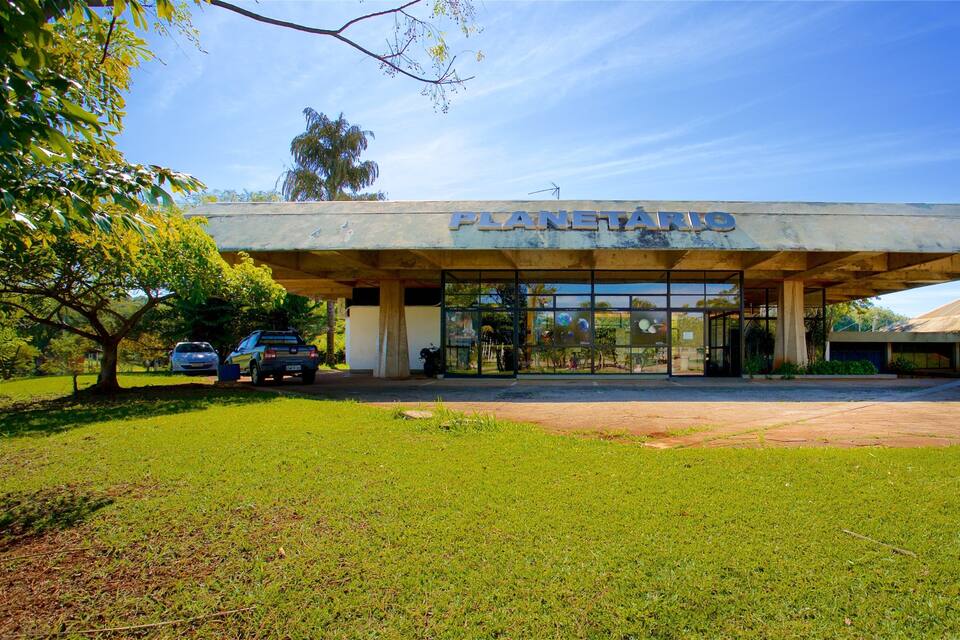 A building with a sign reading "PLANETARIO" under a large overhang.