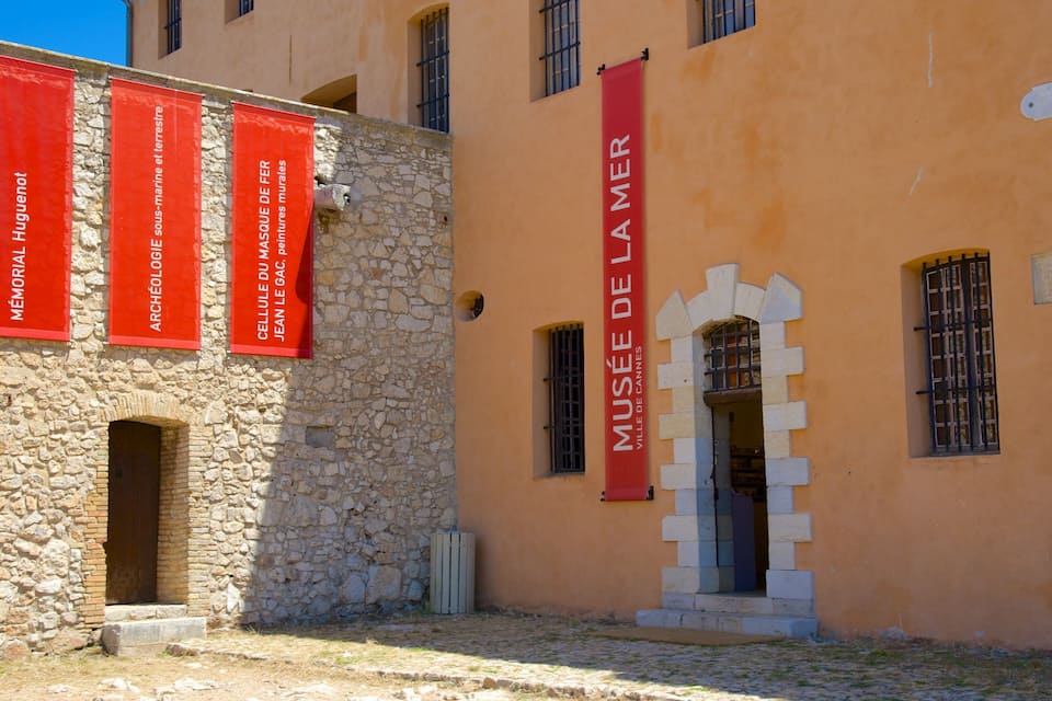 Ein Gebäude mit Steinmauern und roten Bannern.