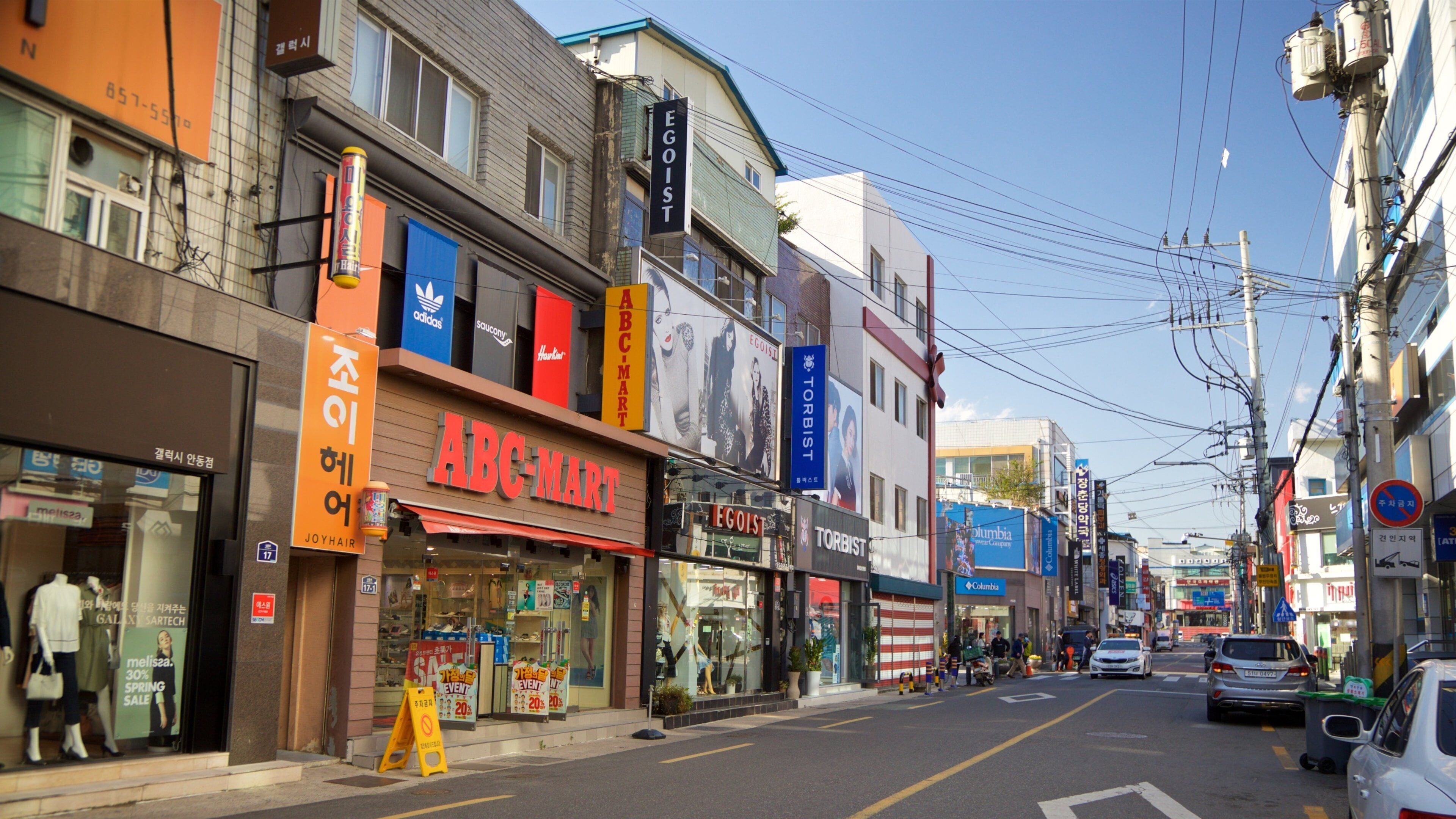 Uma rua repleta de lojas diversas, incluindo a ABC-Mart e a EGOIST.