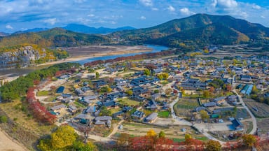 Uma cidade montanhosa com casas tradicionais, um rio e folhagem de outono.