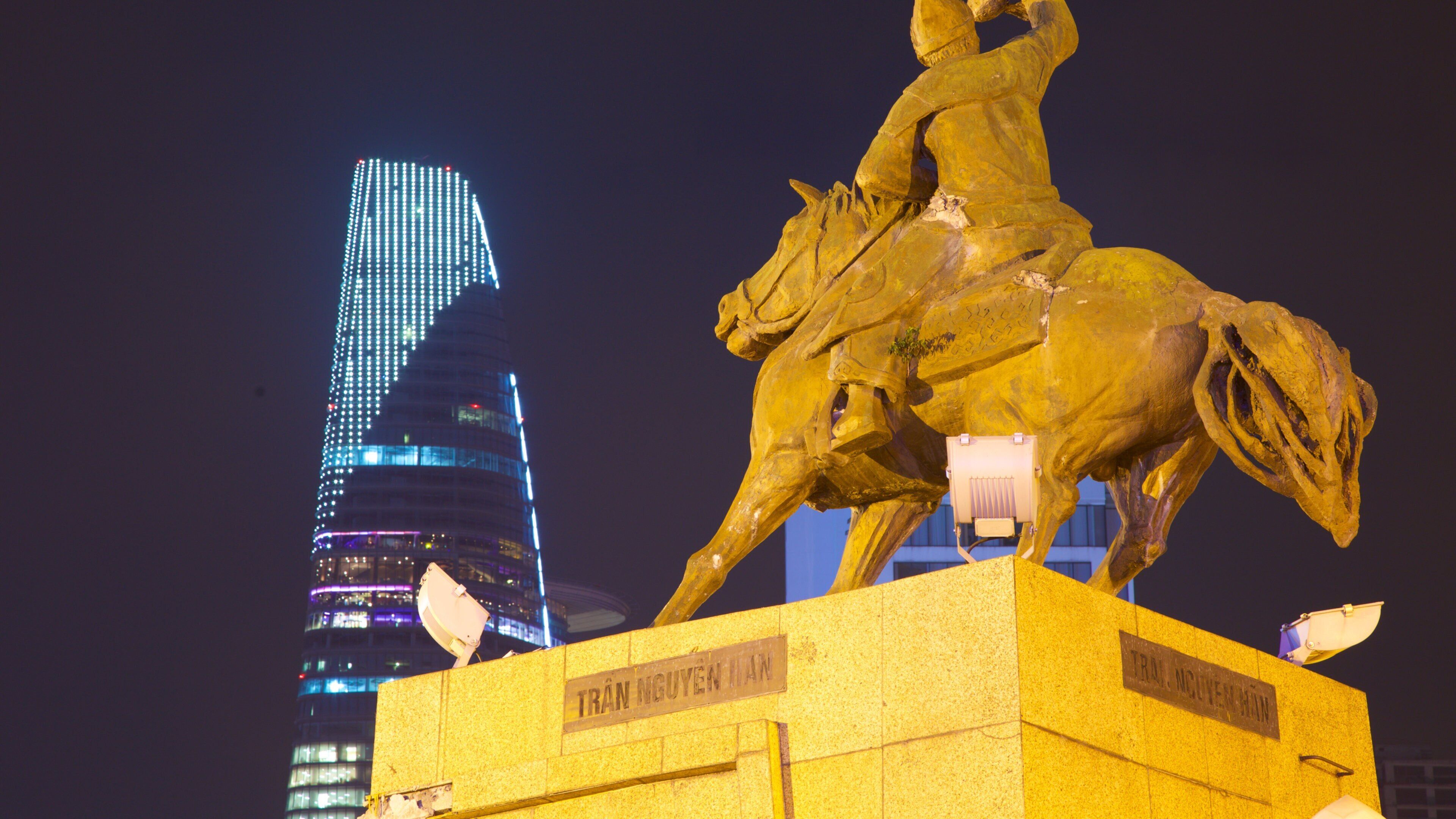 Saigon Skydeck which includes night scenes, a skyscraper and a statue or sculpture