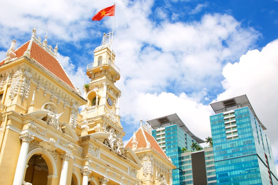 A historic building with ornate architecture and a modern skyscraper in the background.